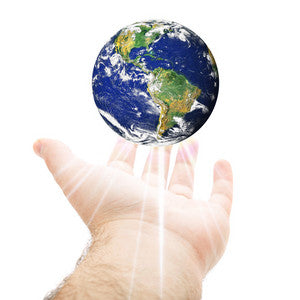 A hand reaching out to hold a floating globe of Earth.
